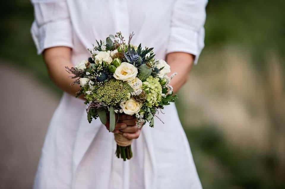 Brautstrauß "Jules" in grün, altblau und cremeweiß mit Rosen und Disteln, ideal für Sommerhochzeiten.